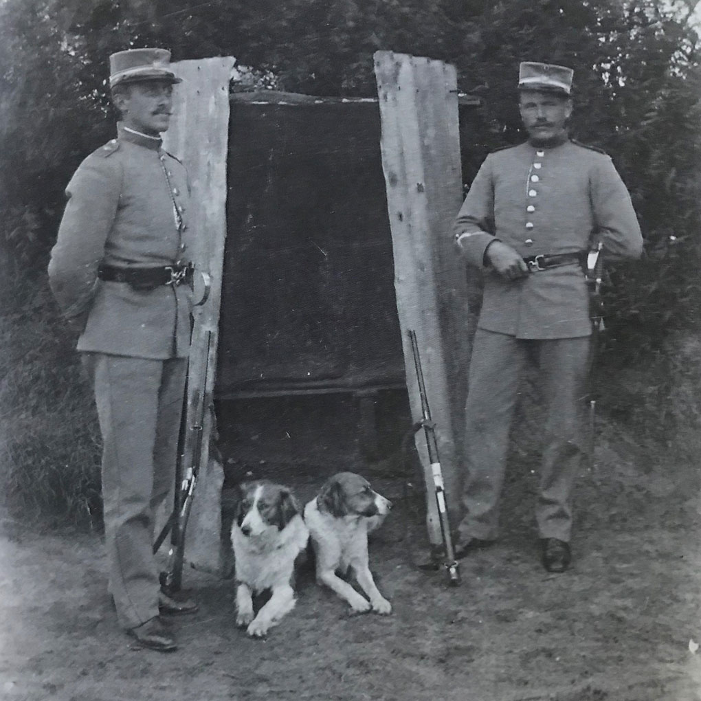 To grænsegendarmer med hunde på vagt ved Klåby i 1909. Selvom det var forbudt, opførte gendarmerne små læskure, som skærmede mod vejr og vind.  